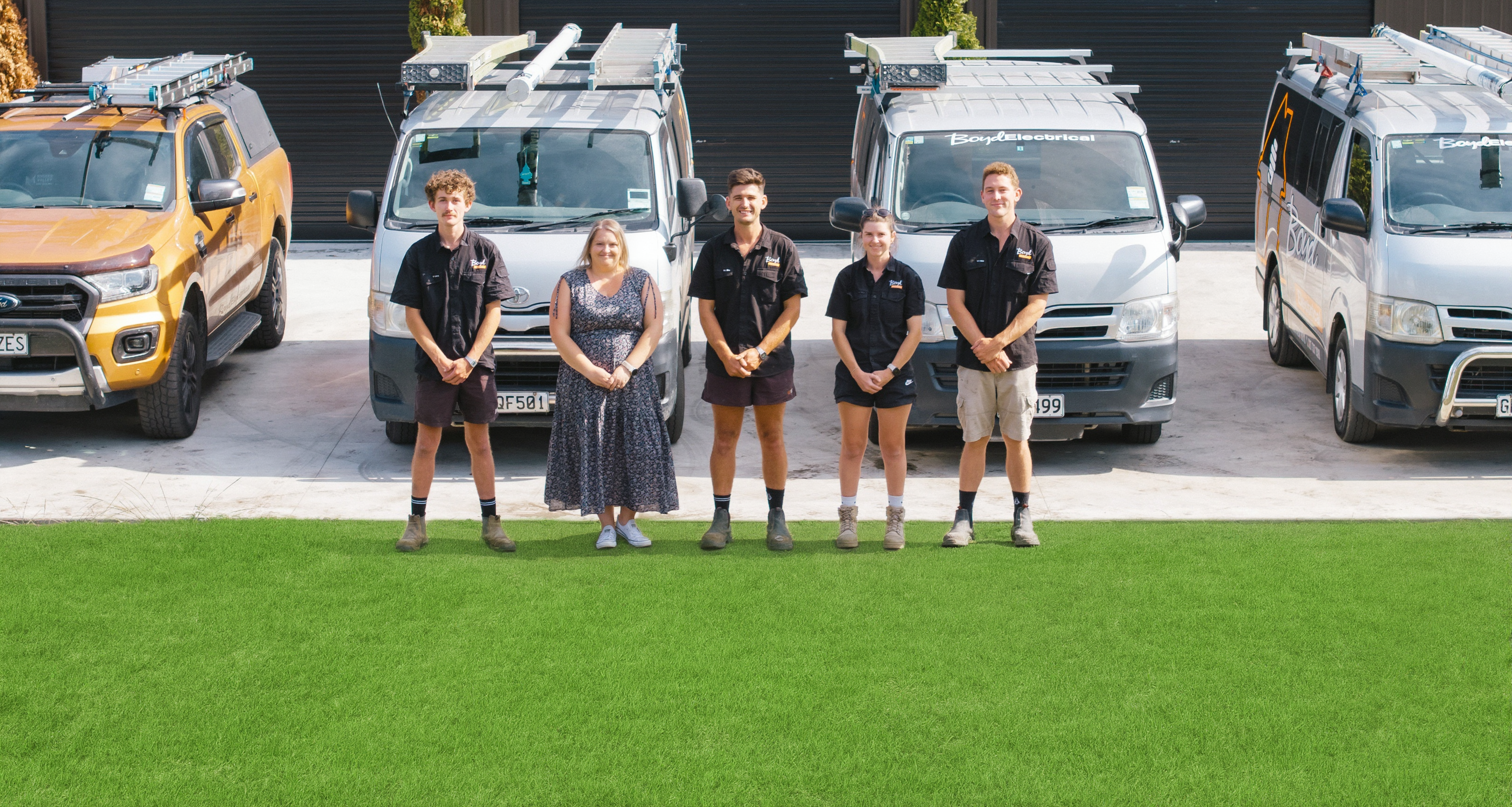 Boyd Electrical Whanganui team standing in front of their fleet of branded work vehicles