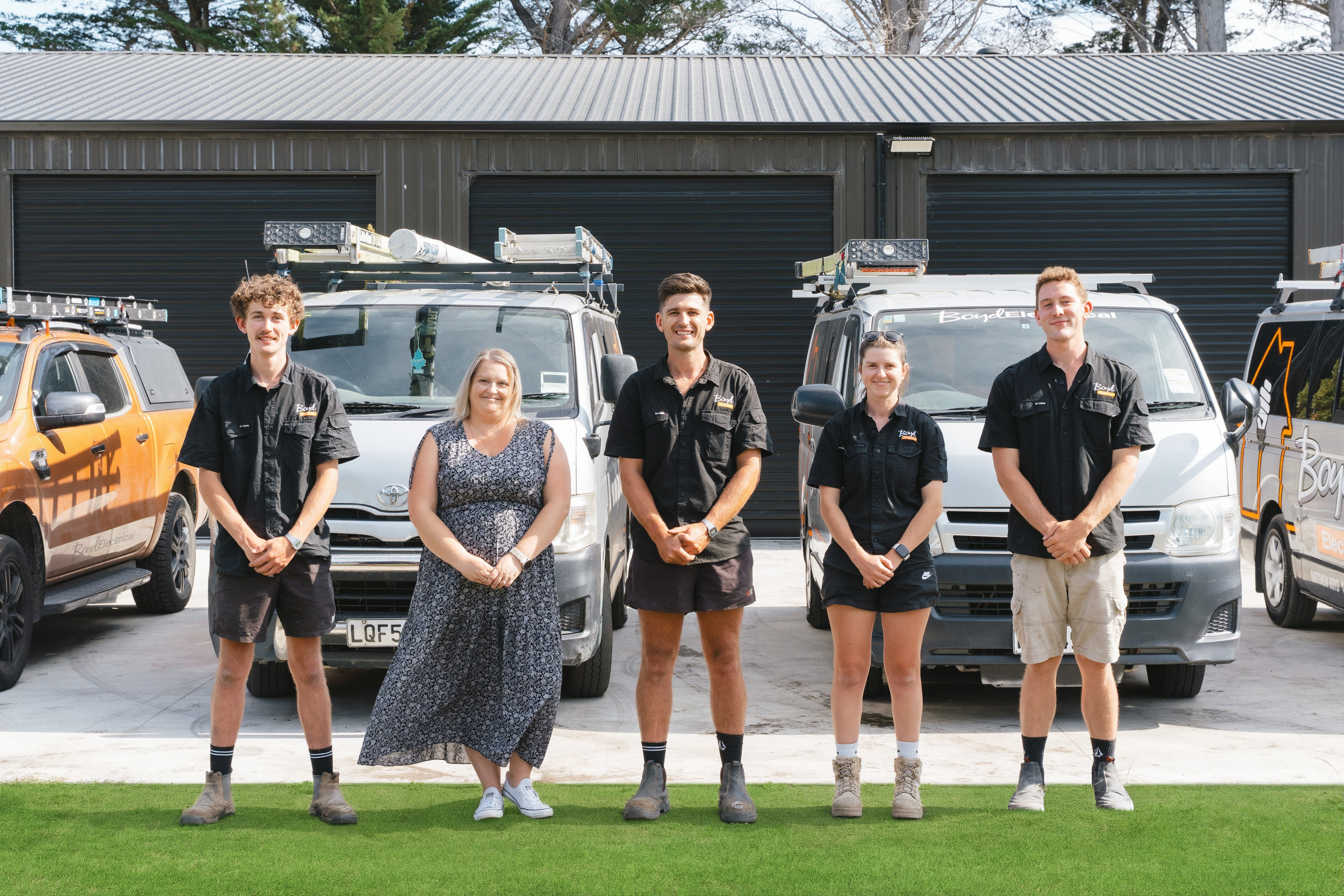 Boyd Electrical Whanganui team in front of their branded work vans at the workshop